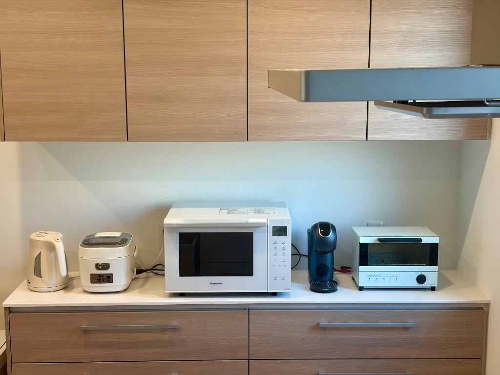 ハグミーのカップボード(ベーシックタイプ)に炊飯器・電子レンジ・トースター・コーヒーメーカー・電気ケトルの5台の家電を並べた様子